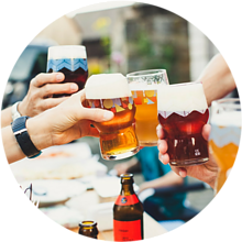 friends toasting their beers together at a table - HSVSheds.com