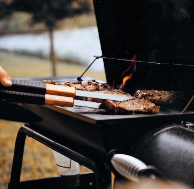 person bbq-ing some meat - hsvsheds.com